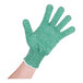 A hand wearing a green San Jamar cut resistant glove with white trim.