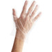 A hand in a medium clear plastic glove.