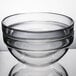 An Arcoroc clear glass ingredient bowl with a rim on top.