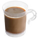 A clear plastic WNA Comet coffee cup filled with brown liquid.