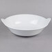 A white GET Siciliano bowl with a handle on a gray surface.