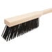 A Carlisle long handled wooden pizza oven brush with black bristles.