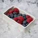 A GET Create-a-Bar deli crock filled with blueberries and raspberries on ice.