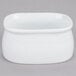 A white rectangular porcelain bowl with a lid on a gray surface.