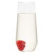 A WNA Comet clear plastic stemless flute filled with a clear liquid and a raspberry.