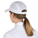 A woman wearing a white Headsweats 5-panel cap with a ponytail.