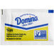 A white Domino sugar packet with blue and yellow text.