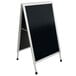 An Aarco satin aluminum A-frame sign with a black chalk board and white frame.