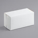 A white 8" x 4" x 4" bakery box with a lid on a gray surface.