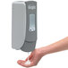 A hand using a GOJO soap dispenser.
