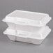 A stack of two white Genpak foam containers with hinged lids.