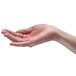 A hand using GOJO floral lotion hand soap.