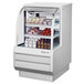 A Turbo Air white refrigerated deli case with food inside.