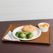 A Cambro earthen gold dietary tray with a sandwich, broccoli, and a piece of bread.
