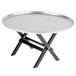 A Tablecraft mini table tray stand with black legs holding a plate on a round table.