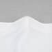 A close-up of a white fabric with a folded edge.