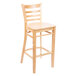 A Lancaster Table & Seating wooden bar stool with a natural wood seat and ladder back.