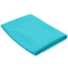 A teal square cloth table cover folded up on a white background.