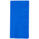A folded cobalt blue paper dinner napkin on a white background.