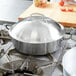 A Vollrath Miramar brazier pan on a stove top.