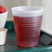 A Dart Y5 Conex translucent plastic cup with red liquid in it.