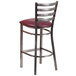 A Clear-Coated metal restaurant barstool with a burgundy vinyl seat.