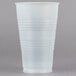 A Dart Y24 Conex translucent plastic cold cup with a white lid on a gray surface.