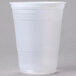 A Dart translucent plastic cup with a lid on a gray surface.