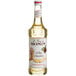 A 750 mL bottle of Monin Premium White Chocolate Flavoring Syrup with a white label.