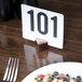 A plate of food with a number in a American Metalcraft hammered copper table card holder.