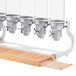 A Cal-Mil beechwood rack holding 5 glass cereal dispensers.