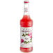 A Monin Premium Rose Flavoring Syrup 750 mL bottle with a label.