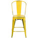 A yellow metal restaurant bar stool with a vertical slat back.