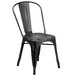 A Flash Furniture black metal restaurant chair with a vertical slat back and drain holes.