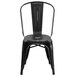 A Flash Furniture black metal chair with a vertical slat back and drain hole seat.