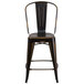 A distressed copper metal restaurant bar stool with a back.