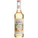 A bottle of Monin White Peach Syrup with a label on a white background.