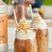 Two mason jars filled with ice cream drizzled with Monin Dulce de Leche flavoring sauce.
