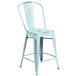A blue metal counter height stool with a slat back and drain hole seat.