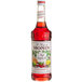 A close up of a Monin Premium Red Sangria Mix bottle filled with red liquid.