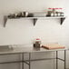 A Regency stainless steel wall shelf with food items on it.