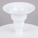 A white Elite Global Solutions round melamine plate stand on a white table.