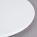 An Elite Global Solutions white melamine plate on a grey surface.