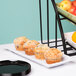 An Elite Global Solutions white rectangular melamine tray with muffins and fruit on it.