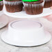 A hand holding a white plate with cupcakes on a white Elite Global Solutions M5P pedestal.
