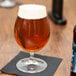 A Spiegelau stemmed Pilsner glass of beer on a table