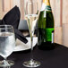 A table with a Spiegelau Adina Prestige flute of champagne and a glass of water next to a napkin.