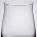 A close up of a clear Spiegelau whiskey tumbler with a curved bottom.