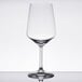 A clear Spiegelau red wine glass on a table with a reflection.