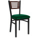 A BFM Seating black metal side chair with a green cushion.